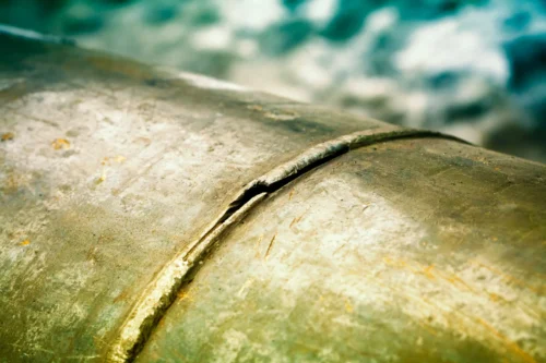 Close-up of a cracked weld on metal equipment, highlighting thermal cracking.